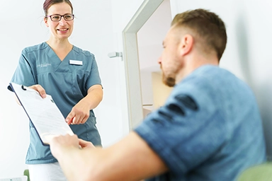 S. Eppers in Gespräch mit Patient in Wartezimmer.
