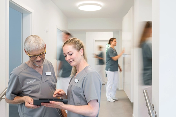 Besprechung der Zahnärtzte, im Hintergrund die Mitarbeitenden.