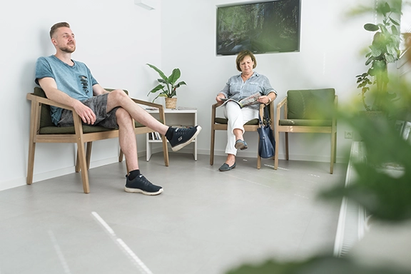 Wartezimmer der Zahnarztpraxis mit zwei Patienten.
