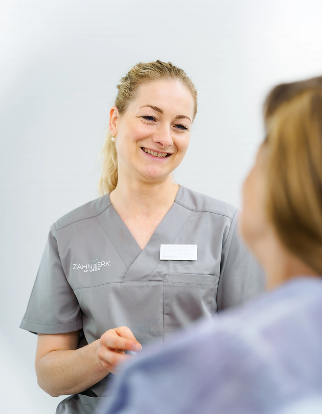 Maria Knöchelmann-Deerberg lächelnd in Gespräch mit Patientin.
